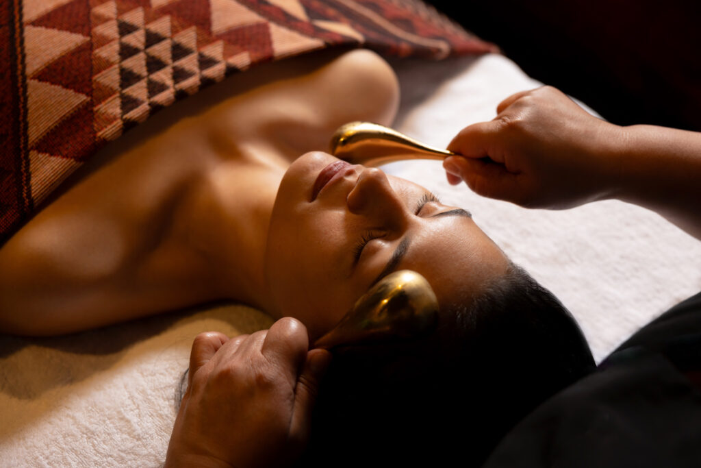 Guest receiving the Wai Ariki Signature Facial, with warm and cool gold tools used during the fire and ice technique.