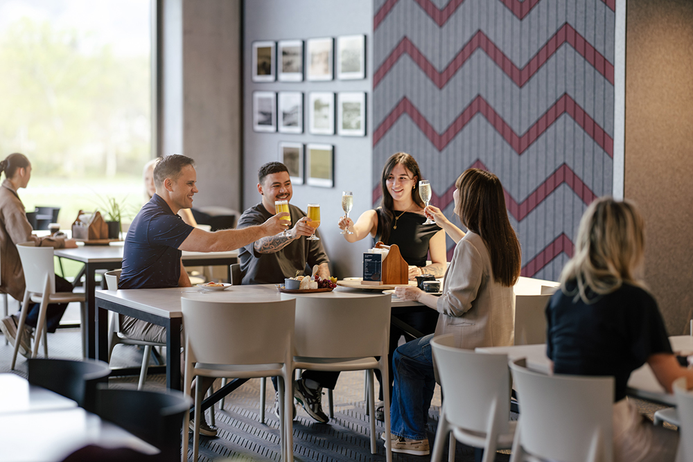 Guests raising a toast with drinks around a grazing platter at Wai Ariki's café, Te Rourou.
