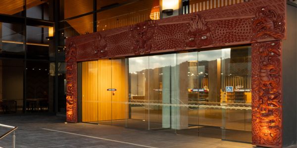 The pare (carved lintel) and whakawae (carved side panels) frame the entrance, carrying connections to tūpuna (ancestors), protection and the story of Ngātoroirangi.