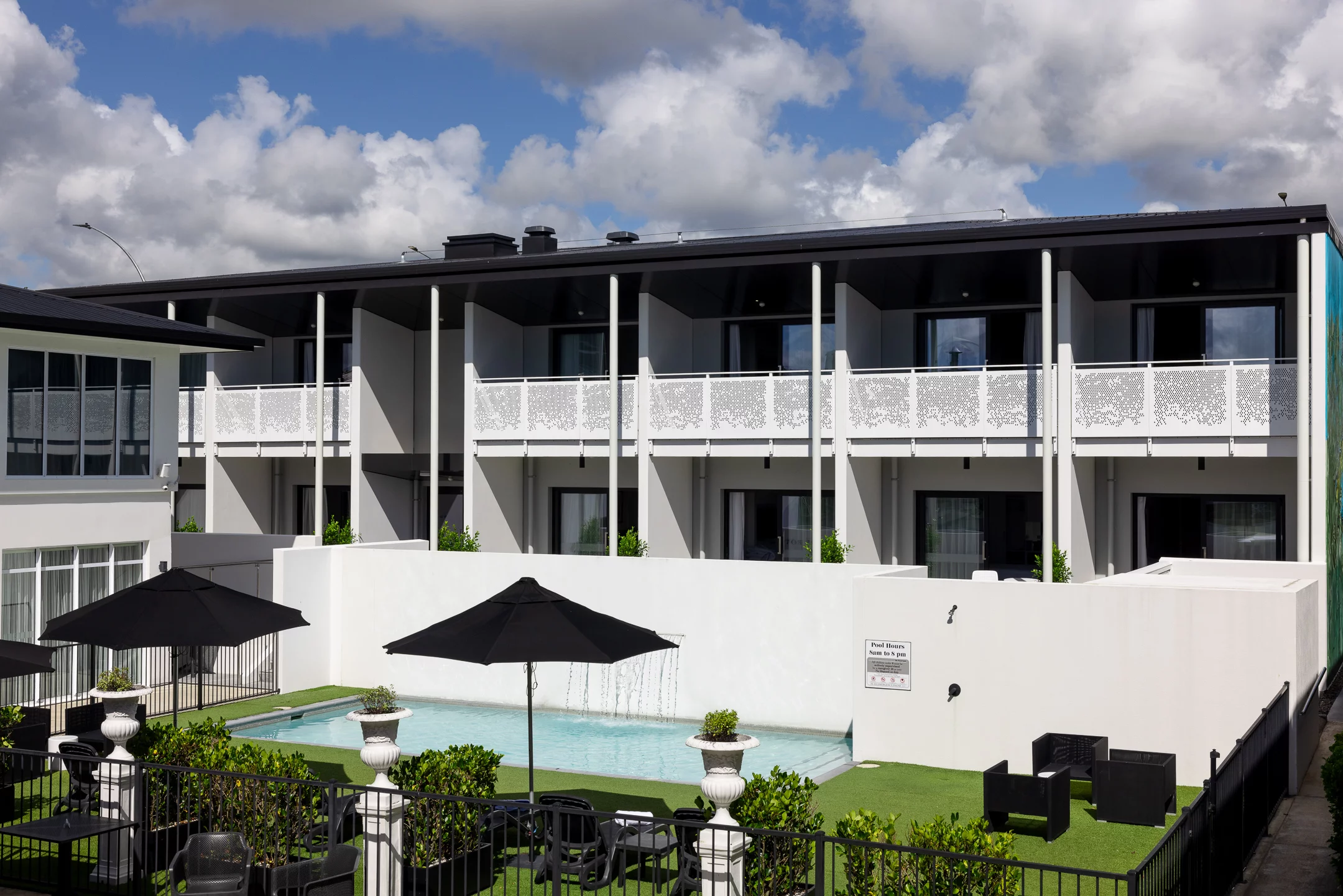 Regent of Rotorua boutique hotel with white balconies overlooking the courtyard pool.
